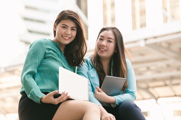 Donne asiatiche di affari di stile di vita due che lavorano al computer portatile di tecnologia