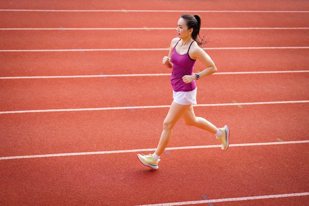 Donne asiatiche di mezza età in esecuzione durante la mattina di sole sulla pista dello stadio