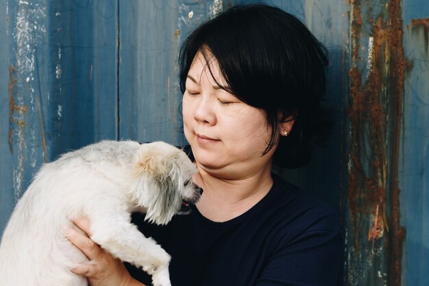 Donne asiatiche e cane che abbraccia felice con il contenitore