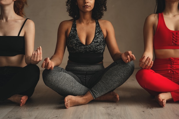 Donne atletiche in forma che fanno yoga, autocontrollo. Belle donne che lavorano insieme in palestra.