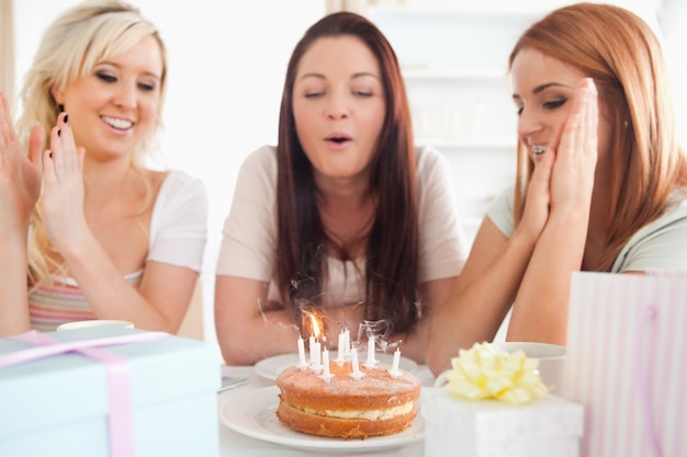 Donne bellissime che si siedono a un tavolo con una torta