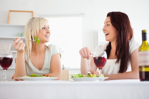 Donne carine che mangiano insalata