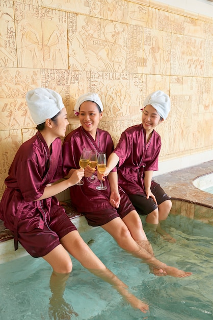 Donne che celebrano con champagne alla spa