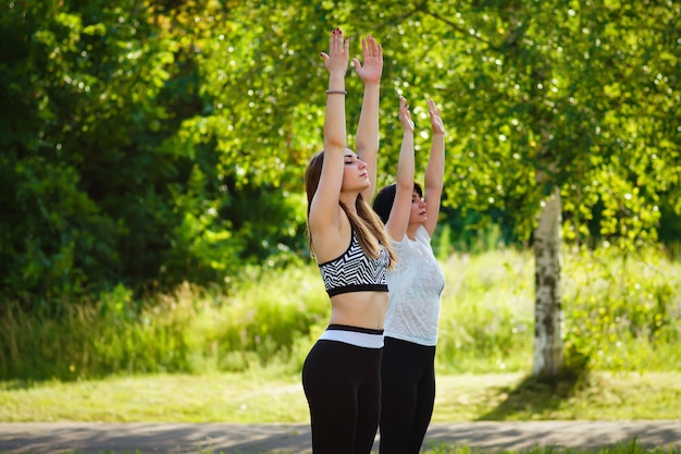 Donne che fanno yoga nel parco estivo