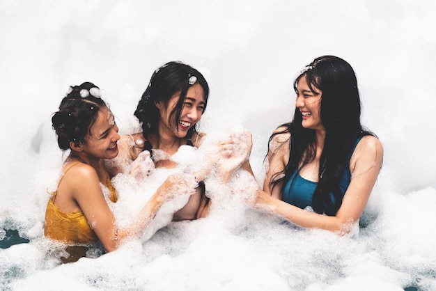 Donne che giocano nella piscina di bolle con divertimento e gioia