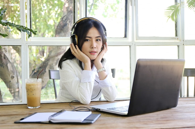 Donne che indicano lo schermo del computer portatile e computer portatile di battitura a macchina dell'uomo sulla tavola di legno, Internet delle cose