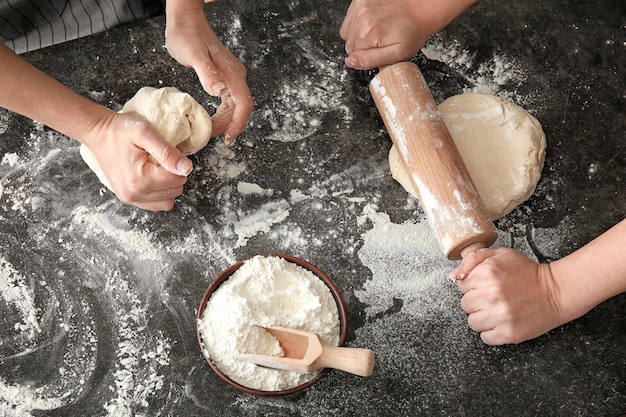 Donne che lavorano con la pasta sul primo piano della tavola