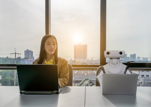 Donne che lavorano e computer robot nel settore degli uffici RPA Robotic Process Automation