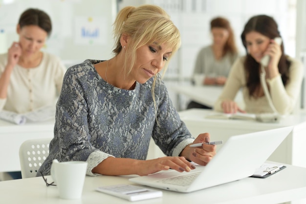 Donne che lavorano insieme in ufficio utilizzando dispositivi digitali