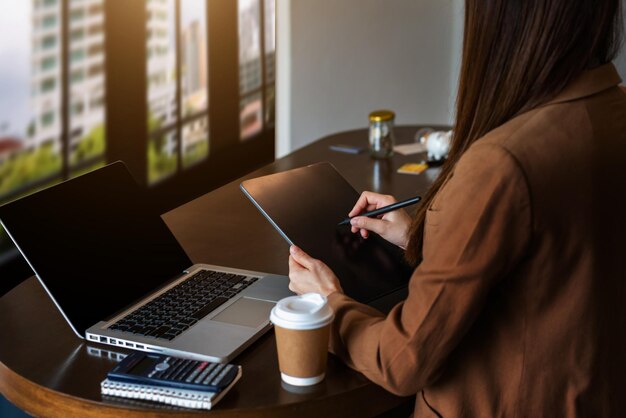 Donne che lavorano laptop e sul tavolo bianco in ufficio a casa. nella luce del mattino