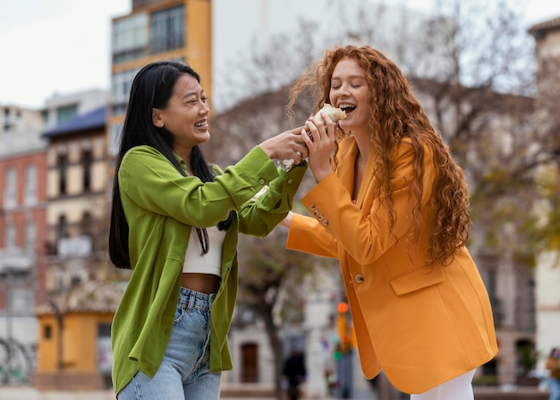 Donne che mangiano cibo di strada all'aperto