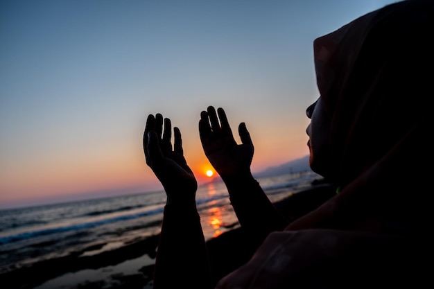 Donne che pregano Allah in spiaggia al tramonto