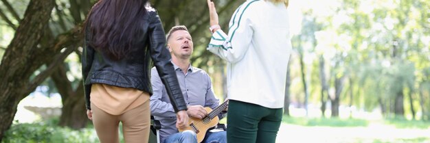 Donne che si divertono con l'uomo disabile in sedia a rotelle nel parco