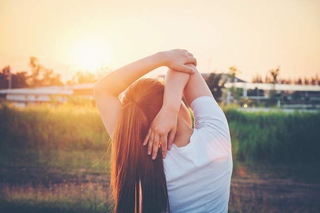 Donne che si esercitano nella luce intensa soleggiata nel parco