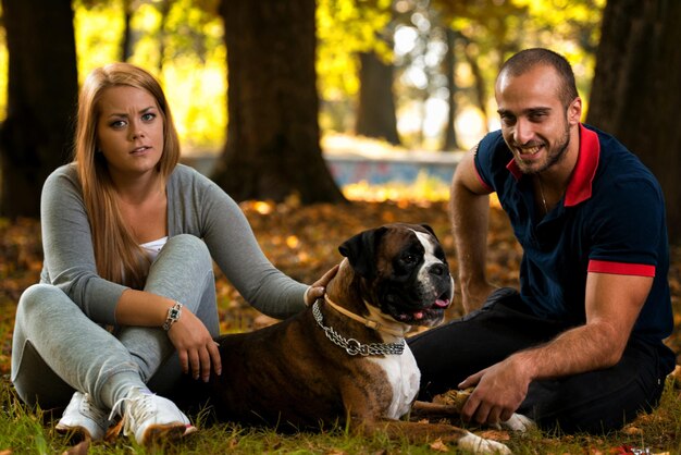 Donne che si siedono all'aperto con il suo pugile tedesco del cane da compagnia