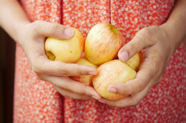 Donne che tengono molti frutti arancioni