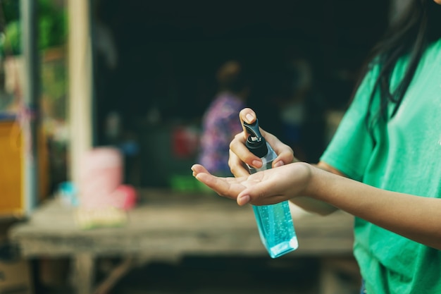 Donne che usano gel alcolico, disinfettante per le mani, pompa erogatrice per le mani