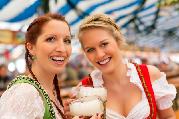 Donne con abiti tradizionali bavaresi o dirndl nella tenda della birra