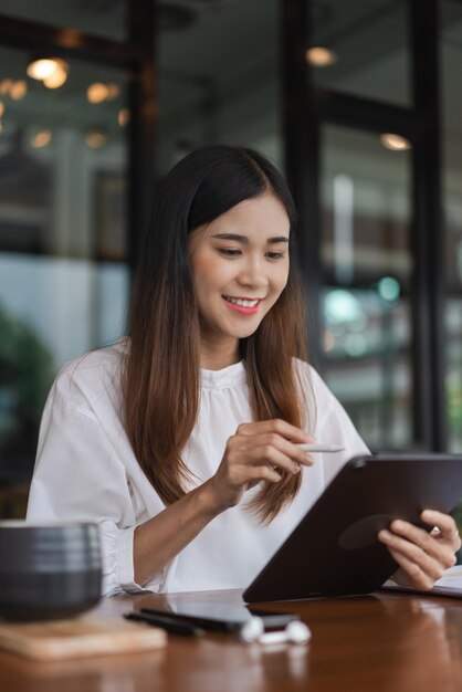 Donne d'affari che leggono i dati aziendali sul tablet e prendono appunti mentre lavorano fuori dall'ufficio