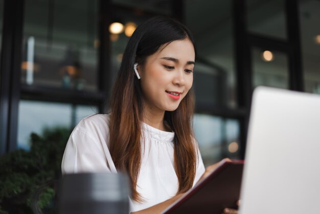 Donne d'affari che leggono i dati sul portatile e controllano i documenti aziendali mentre si incontrano in videochiamata