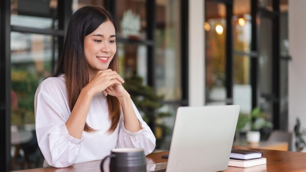 Donne d'affari che leggono i dati sul portatile per l'analisi di nuove start-up mentre lavorano in un ufficio esterno