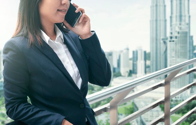 Donne d'affari che usano il telefono fuori dall'edificio per uffici