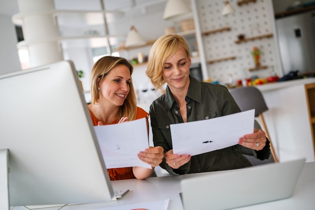 Donne d'affari felici che lavorano insieme in ufficio