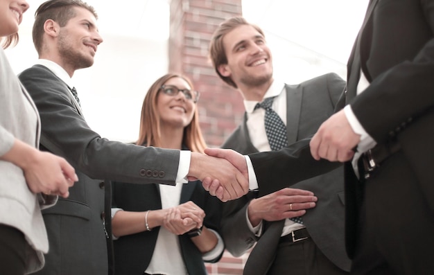 Donne d'affari felici che stringono la mano in ufficio