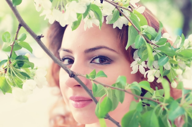 donne dai capelli rossi in un ramo di fiori di melo