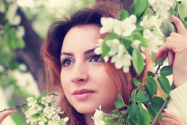 Donne dai capelli rossi in un ramo di fiori di melo