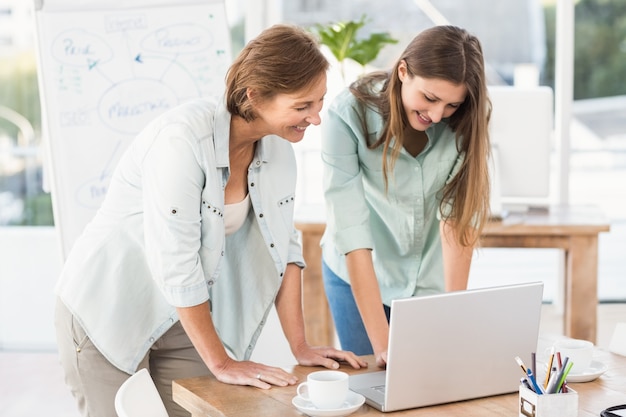 Donne di affari casuali che lavorano con il computer portatile