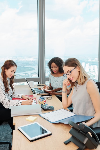 Donne di affari che lavorano con documenti e compresse