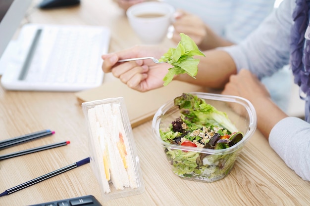 Donne di affari che mangiano scatola di insalata e scatola di sandwich di uova. pranzare per lavoro con la collaborazione sul posto di lavoro.