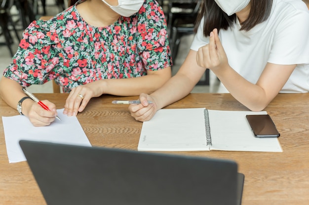 Donne di affari con la mascherina medica che lavorano insieme