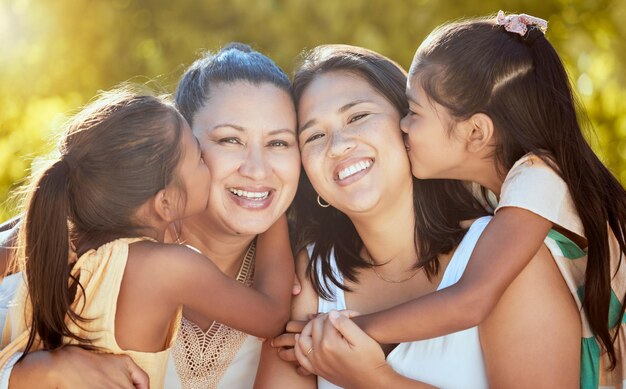 Donne di famiglia e bacio dei bambini al parco con madre nonna e tempo di qualità nella natura Famiglia felice amore e ragazza si godono il divertimento estivo con mamma e nonna nella foresta in estate sorridi e rilassati