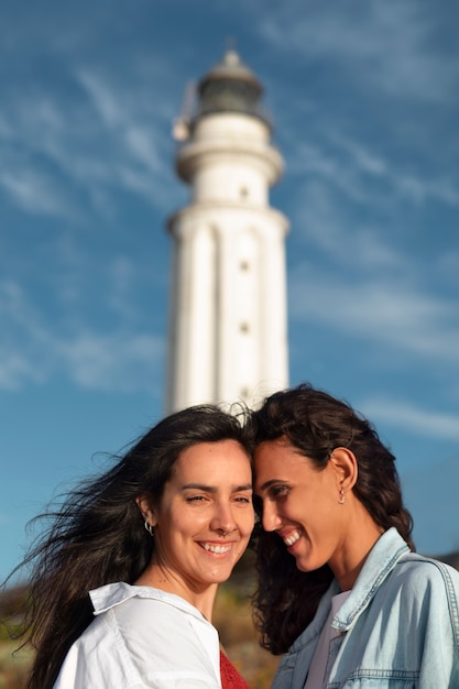 Donne di media foto che posano con il faro