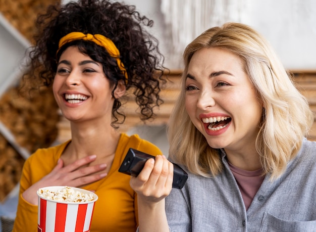 Donne di smiley che ridono mentre guardano un film