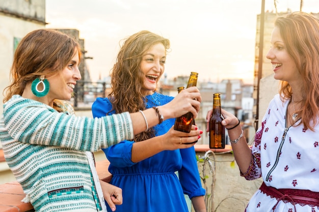 Donne felici che godono di una birra su un tetto a Barcellona