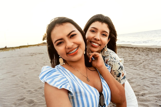Donne felici degli amici che prendono un selfie sulla spiaggia