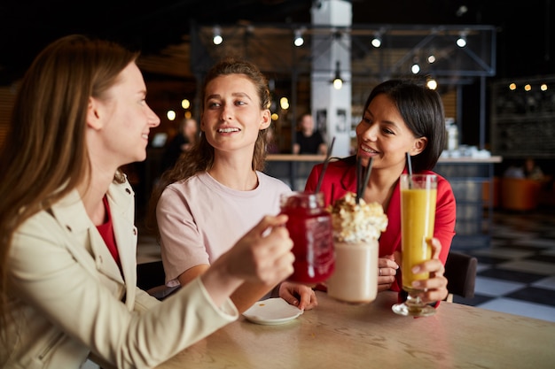 Donne felici divertendosi nel caffè