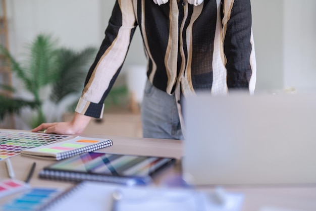 Donne graphic designer che digitano dati sul laptop mentre lavorano sulla progettazione grafica con la tecnologia