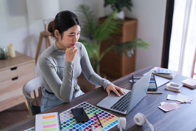 Donne graphic designer che ricercano dati sul laptop per pensare e lavorare sulla progettazione grafica