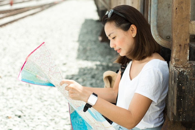 Donne graziose che guardano una mappa per il viaggio in treno la Tailandia