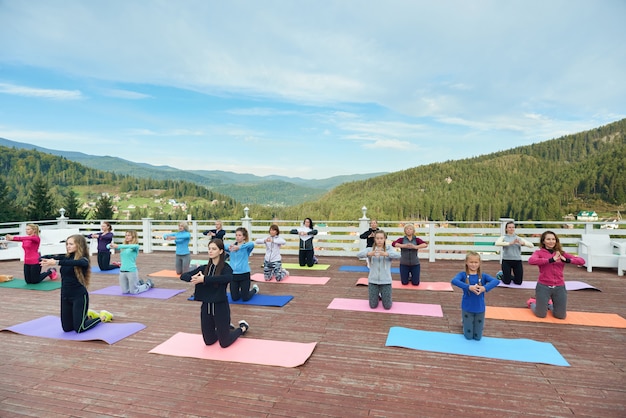 Donne in piedi su stuoie di yoga, praticando.