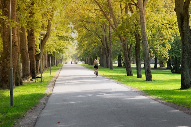 Donne in sella a una bicicletta nel parco della città.