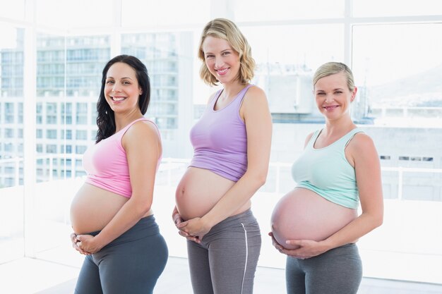 Donne incinte felici che stanno in una fila