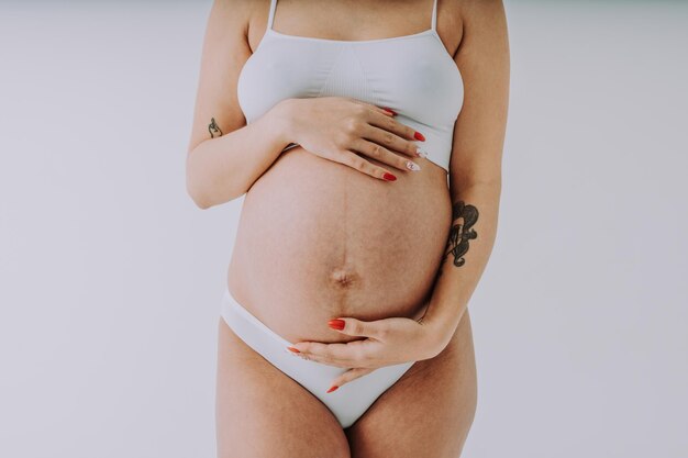 Donne incinte felici con pancia grande su sfondo colorato - Giovani donne che indossano biancheria intima in attesa di un bambino - Concetto di gravidanza, maternità, persone e aspettativa