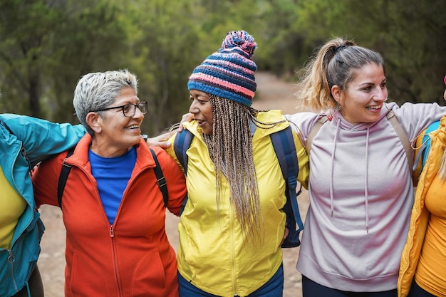 Donne multirazziali che si divertono durante la giornata di trekking nel bosco - Focus sul volto femminile africano