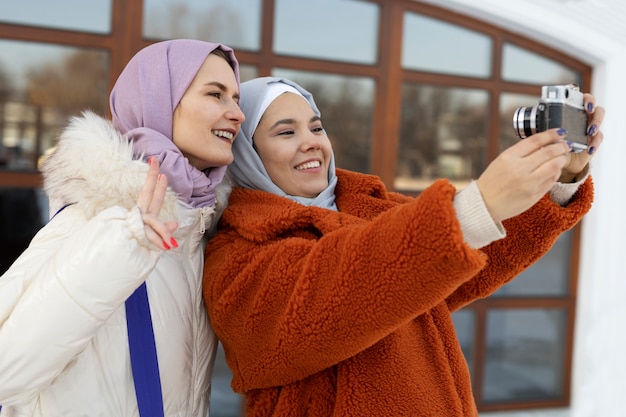 Donne musulmane che si fanno un selfie e mostrano il segno della pace mentre sono in vacanza