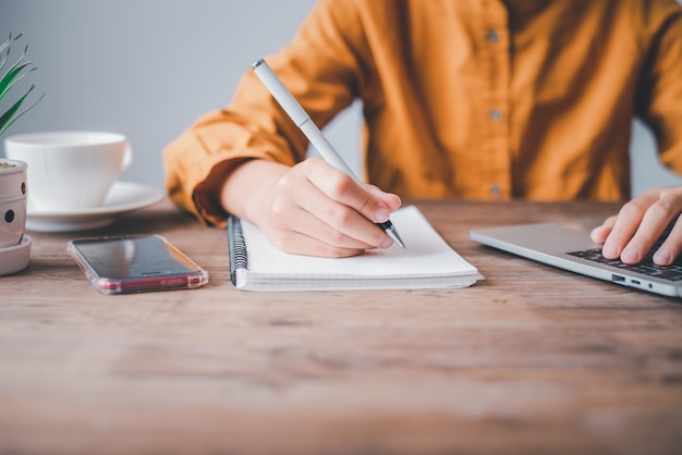 Donne sedute e prendere appunti mentre lavorano a casa. Comunicazione online